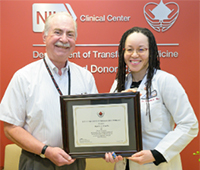 two NIH CC DTM staff members accepting an award