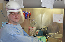 James Dickey wearing protective gear in front of a work station.