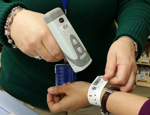 a person scanning a barcode bracelet