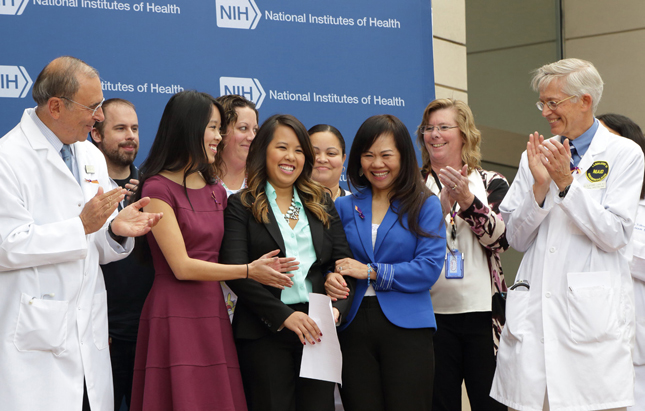 Group photo of Nina Pham, her sister, mother and NIH doctors, nurses and senior leaders