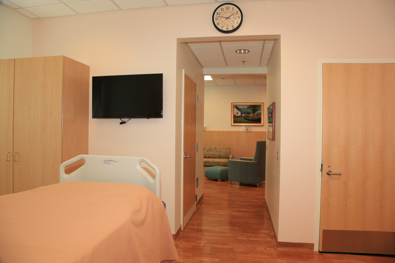 A picture of a patient bed, with a family area in the foreground