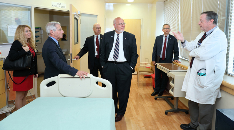 CDC and NIH representatives stand in a special isolation patient room at the NIH Clinical Center