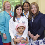 A pediatric patient with her mother and members of the NIH Blood Bank